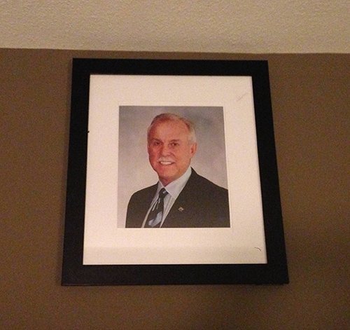 Overseeing the room is the picture of a man. According to some, it is Jay Comeaux, President at Stanford Group Company. Why is this random elite guy on the wall? WHY??